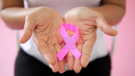 Photo for Close up hand holding pink ribbon. Breast cancer awareness month, Pink Day, World Cancer Day, National Cancer Survivor Day - Royalty Free Image