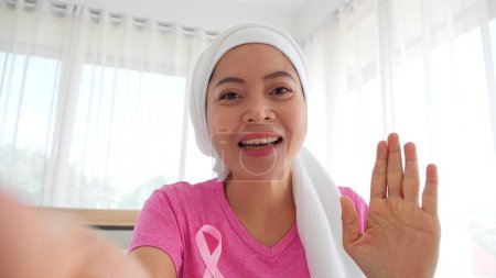 Téléchargez les photos : Patients atteints de cancer du sein turban blanc sur la tête parler par appel vidéo Salutations et encouragement aux femmes qui luttent contre le cancer dans le monde. en regardant l'écran de la tablette - en image libre de droit