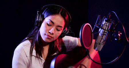 Téléchargez les photos : Femme asiatique jouant de la guitare acoustique solo intro dans les chansons d'enregistrement en studio - en image libre de droit