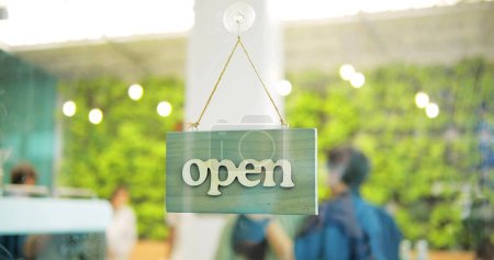 Téléchargez les photos : Un panneau d'affaires qui dit Ouvrir sur un café ou un restaurant accrocher à la porte à l'entrée - en image libre de droit