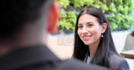 Téléchargez les photos : Belle femme d'affaires portant des vêtements formels parle affaires avec un visage souriant - en image libre de droit