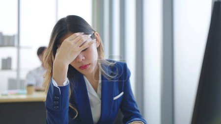 Téléchargez les photos : Gros plan épuisé visage de l'employée femme stressé malheureux sentiment assis et travailler sur le bureau au bureau - en image libre de droit