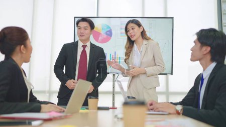 Foto de Dos profesionales de negocios, hombres y mujeres asiáticos hacen presentaciones en la sala de reuniones en la oficina - Imagen libre de derechos