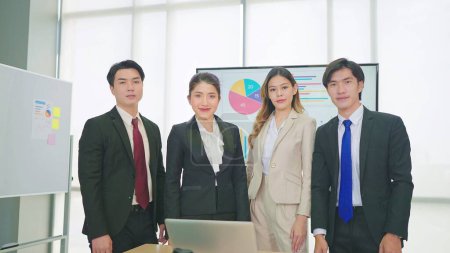 Téléchargez les photos : Un groupe de jeunes professionnels asiatiques d'affaires portant un costume debout et regardant la caméra - en image libre de droit