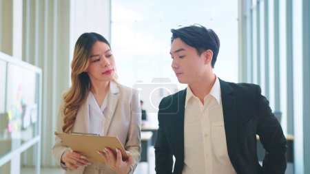 Photo for Two asian businesspeople walking and talking about their business in modern corporate office - Royalty Free Image