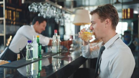 Téléchargez les photos : Un homme d'affaires buvant du whisky au restaurant. Patron réussi passer du temps en place avec de l'alcool cher - en image libre de droit