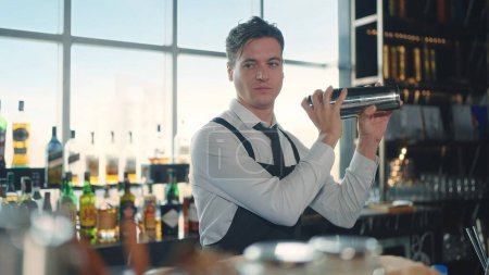 Photo for The profession bartender. Making a cocktail at bar in a restaurant. The bartender mixes the ingredients of an alcoholic cocktail by shaking a shaker - Royalty Free Image