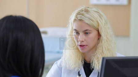 Photo for Caucasian woman plastic surgeon talking to asian woman patient sitting in treatment room at hospital - Royalty Free Image