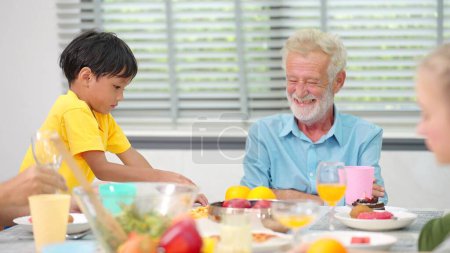 Photo for Grandfather and grandson play on the dining table and have fun during lunch at home. Family time - Royalty Free Image