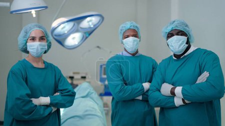 Photo for Professional surgeon team in arms crossed position looking confidence into the camera. after successful surgical operation in the hospital - Royalty Free Image