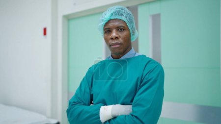 Photo for Portrait of African American man professional surgeon in arms crossed position looking confidence into camera. after successful surgical operation in the hospital - Royalty Free Image
