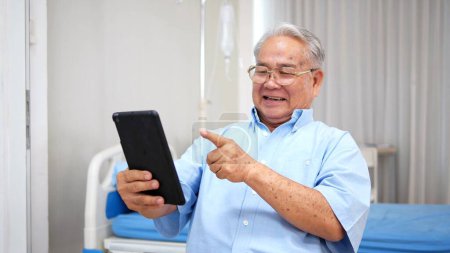Photo for Happy Asian elderly patient sitting on wheelchair and making video call with tablet at hospital. elderly people healthcare concept - Royalty Free Image