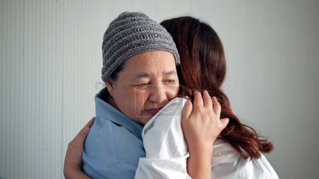 Foto de Nieta asiática está dando un abrazo efectivo a su abuela como signo de amor y respeto en la cama en el hospital - Imagen libre de derechos