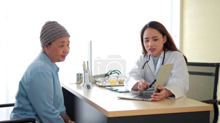 Foto de Mujer asiática doctora y anciana paciente hablando en clínica. Atención médica y de salud, asesoramiento y concepto de terapia - Imagen libre de derechos