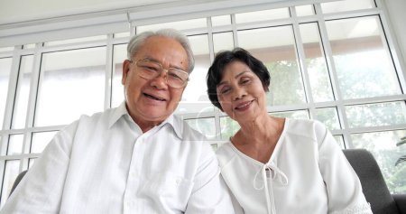Téléchargez les photos : Heureux asiatique mature senior couple parler à caméra à la maison alors que vidéo appel - en image libre de droit