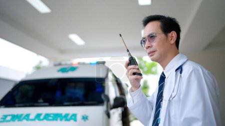 Photo for Paramedic using a radio to report an emergency at hospital - Royalty Free Image