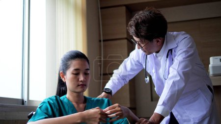 Photo for Asian doctor encouraged and talked to serious patient sitting on wheelchair while medical examination in hospital ward. Bad news, Bad health results make the patient unhappy - Royalty Free Image