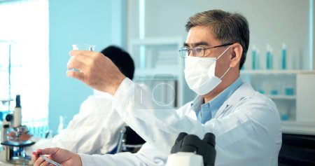 Photo for Asian scientists test using science tubes to research and treat illness in a lab or hospital. Medical treatment concepts, science laboratory research and development concept - Royalty Free Image