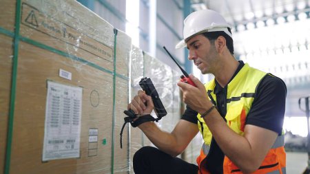 Photo for Professional young engineer man holding barcode scanner and radio communication talking with colleague to inspect the products in the factory Industrial - Royalty Free Image