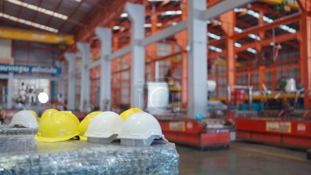 Close up of white and yellow safety helmets on the table at industry factory. Safety helmets on table for construction safety. Security concept