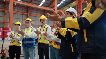 Téléchargez les photos : Équipe de travailleurs d'usine applaudissant les mains pour célébrer le succès dans l'usine. Célébrez le succès du concept de projet - en image libre de droit