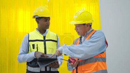 Photo for Two professional factory warehouse workers holding tablet and radio communication talking and disussing for work in factory - Royalty Free Image