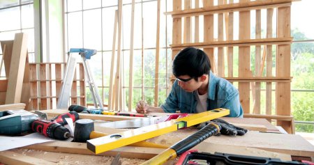 Photo for Carpenter man working on wood craft to produce construction material or wooden furniture. The young Asian carpenter use tools for crafting. DIY maker and carpentry work concept - Royalty Free Image