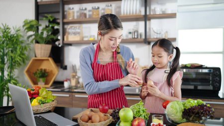 Photo for Asian family, mother and daughter enjoy cooking vegetable spending time together in kitchen room at home. Healthy meal and dinner, happy family asian concept - Royalty Free Image