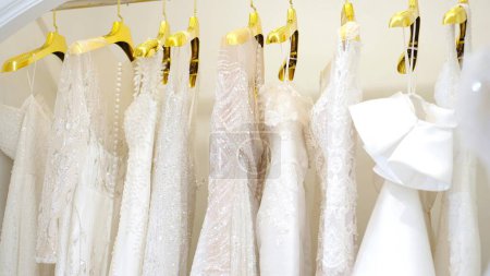 Téléchargez les photos : Belles robes de mariée suspendues aux cintres au studio de mariage - en image libre de droit