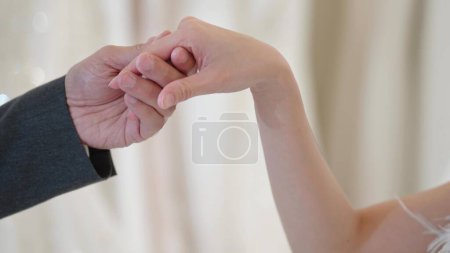 Photo for Close up of married couple holding hands for wedding day ceremony - Royalty Free Image