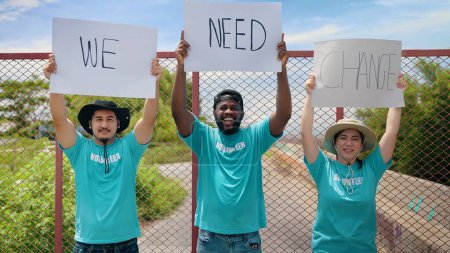Téléchargez les photos : Groupe de bénévoles avec bannière de "We Need Change" protestant contre la pollution et le réchauffement climatique et luttant contre les gens qui protestent contre la pollution des ordures dans les décharges de la banlieue de la ville - en image libre de droit