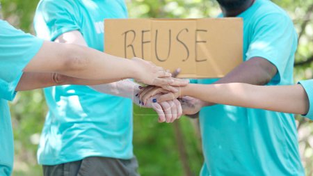Photo for Volunteer to help save nature, pick up trash, hold a re-use sign activists starting work with cheering and stacking hands in the circle - Royalty Free Image