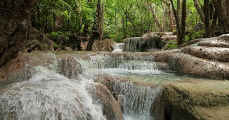 Foto de Cascada de agua esmeralda clara para vacaciones relajarse viaje en la selva verde o bosque en la cascada de Erawan, Parque Nacional de Erawan en Kanchanaburi, Tailandia - Imagen libre de derechos