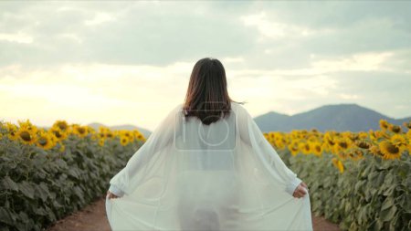 Photo for Back view of young woman against sunflower field. Enjoy in nature. Happy life, tourist break out to rest - Royalty Free Image