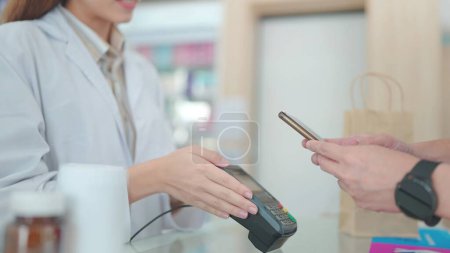 Foto de Un cliente compra medicamentos con farmacéuticos en farmacias y escanea los códigos de barras a los pagos - Imagen libre de derechos