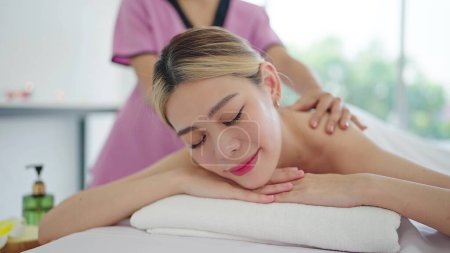 Photo for Close up face of relaxed young Asian woman lying on spa bed closed eyes and relaxed. Spa treatment, body relaxation concept - Royalty Free Image