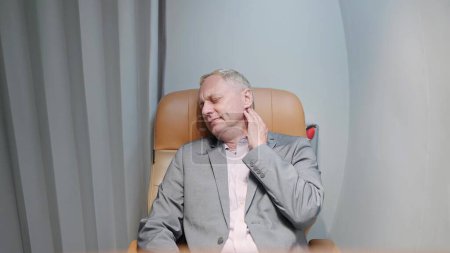 Photo for Middle aged caucasian businessman having neck pain while sleeping on seat of private jet. Painful feeling in the neck - Royalty Free Image