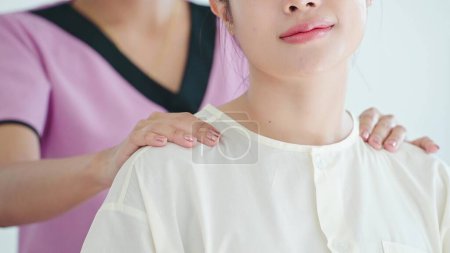 Téléchargez les photos : Gros plan asiatique jeune femme se sentant se détendre pendant les massages des épaules et du dos obtenir un service de physiothérapie de masseuse au salon de spa. Concept de soins corporels - en image libre de droit