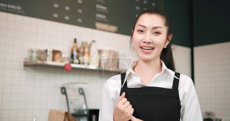 Photo for Portrait of young asian woman barista or owner in apron standing in coffee shop or cafe and looking at camera. Small business concept - Royalty Free Image