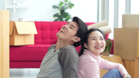 Foto de Feliz joven pareja asiática sentada en el suelo en la sala de estar en la nueva casa en el día de la mudanza. Pareja feliz, Casa móvil - Imagen libre de derechos
