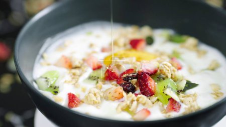 Photo for Honey pouring on fruit berry salad with yogurt and granola for healthy breakfast. Honey, yogurt and fresh berries in bowl. Healthy food concept - Royalty Free Image
