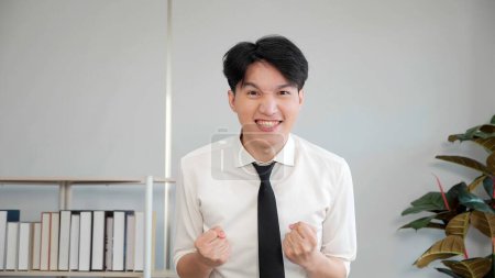 Téléchargez les photos : Jeune homme asiatique a reçu de grandes nouvelles plus haute note réussir des examens ou des tests. Se sent heureux excité, célébrer l'admission à l'université - en image libre de droit