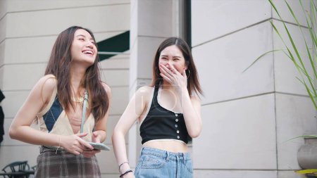 Téléchargez les photos : Heureuse deux jeunes femmes meilleures amies qui rient en marchant dans la rue de la ville à l'extérieur. Les femmes s'amusent - en image libre de droit