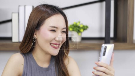 Photo for Happy young asian woman video call through smartphone. Woman video calling distance with friend online in application of smartphone. Technology concept - Royalty Free Image