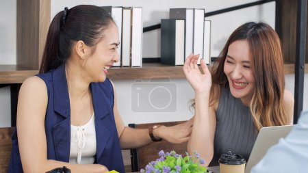 Foto de Dos jóvenes amigas asiáticas disfrutan hablando juntas en la cafetería de vacaciones. Mujer joven y feliz charlando con alegría divertida, reír, relajarse y sonreír. Mujer concepto de estilo de vida - Imagen libre de derechos