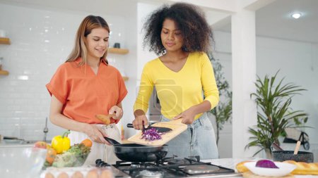 Photo for Happy lesbian couple women enjoy cooking together in kitchen room at home. Two woman spending cooking time together in weekend at kitchen room. Lgbt relationship concept - Royalty Free Image
