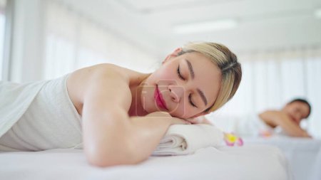 Photo for Close up beautiful young asian woman lying on spa bed relaxing on holiday at spa salon. Woman sleep on spa bed resting after body massage in spa resort. Spa treatment, Body care concept - Royalty Free Image