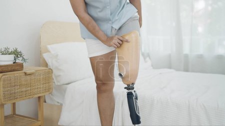 Téléchargez les photos : Fermer amputé portant un équipement de prothèse de jambe après le réveil tous les jours. Difficultés dans la vie des personnes handicapées, Handicap physique, Prothèse de jambe, Concept d'amputé - en image libre de droit