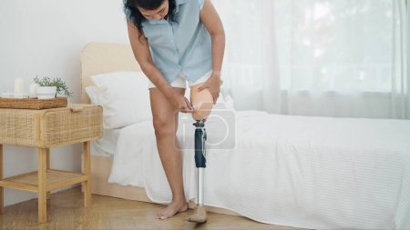 Téléchargez les photos : Fermer amputé portant un équipement de prothèse de jambe après le réveil tous les jours. Difficultés dans la vie des personnes handicapées, Handicap physique, Prothèse de jambe, Concept d'amputé - en image libre de droit