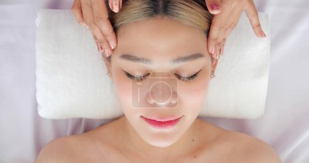 Foto de Cerca de la cara de hermosas mujeres asiáticas recibiendo tratamiento de masaje facial en la clínica de belleza. Tratamiento de belleza en la cara. Belleza masaje facial, concepto de cuidado de la piel - Imagen libre de derechos